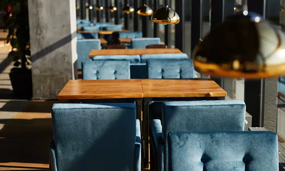 lots of blue velvet single seater sofa booths in a large restaurant