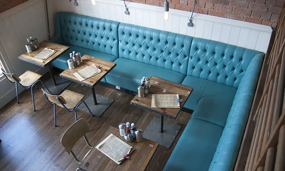 Large L shape banquette set in deep button back style inside an industrial style restaurant