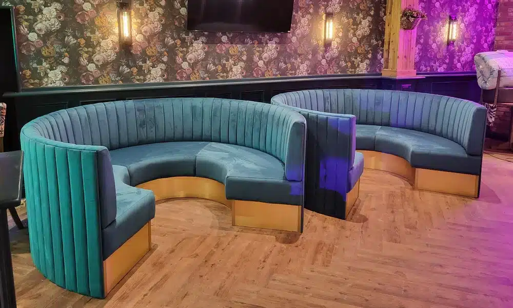 Nightclub bar interior with two round deep fluted booth sets in the centre of the room