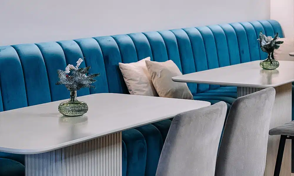 Modern luxury deep fluted banquette seating in a line in deep blue velvet upholstery
