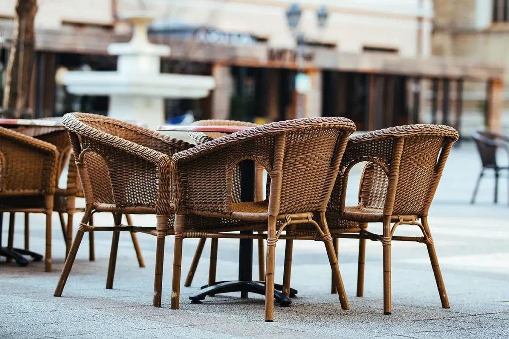 outdoor restaurant set in a weave style, setting, illustrating how different outdoor materials support various dining layout styles.