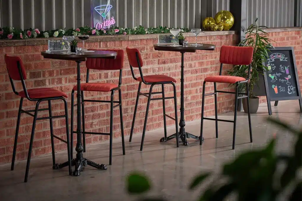 Restaurant tables with different table base styles in a hospitality setting, illustrating how table bases support various dining layouts.