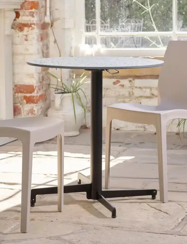 Commercial outdoor table with weather-resistant base and top in a restaurant setting.