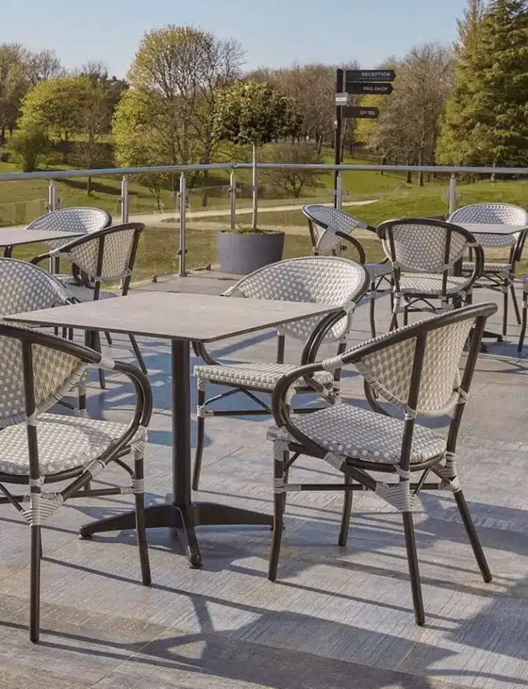 Commercial outdoor dining set with table and chairs arranged in a hospitality terrace.