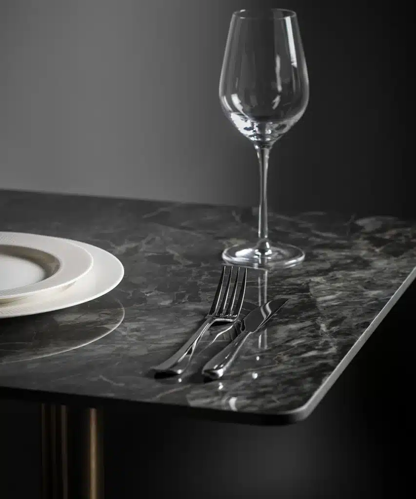 Close up of a black marble style table top with tablewear on top