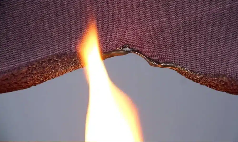 A piece of commercial fabric being lit on fire, showing crib 5 resistance
