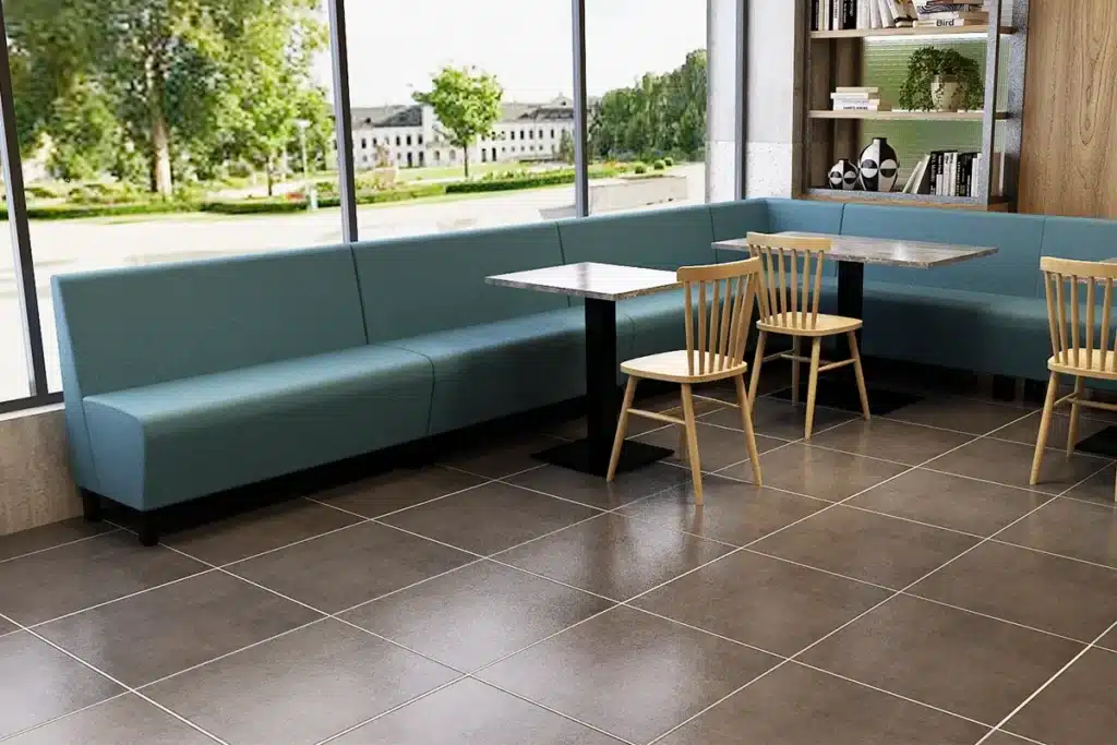 L-shaped banquette seating in a school café or canteen with tables arranged opposite the booth run.