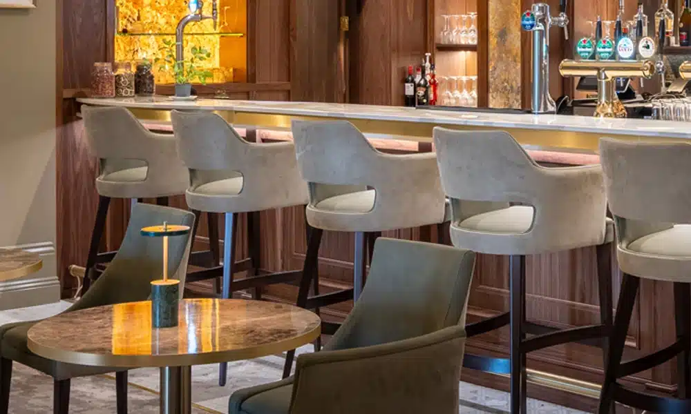 Luxury lounge interior with various upholstered stools and chairs around
