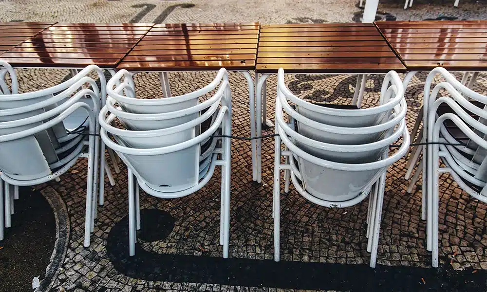 Stackable plastic chairs and metal outdoor tables in a restaurant terrace