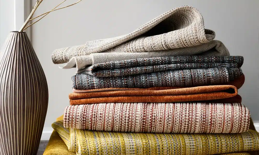 A stack of fabrics in patterned designs on a table