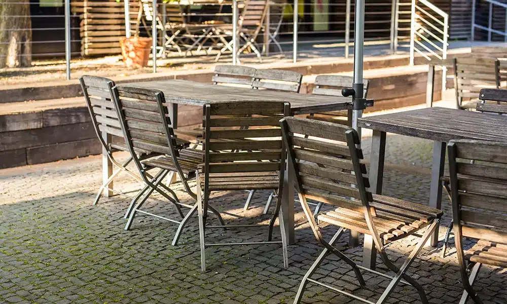 Old antique rustic style wooden folding chairs for commercial outdoor spaces in a pub terrace
