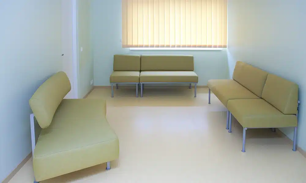 Bright Waiting room with soft booth seating spread out around a UK GP Clinic
