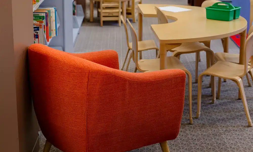 Childs play area in a library, soft upholstered seating and childrens desks and chairs - UK Trade Furniture