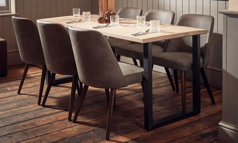 Upholstered restaurant chairs around a oak solid wood table top in a restaurant setting