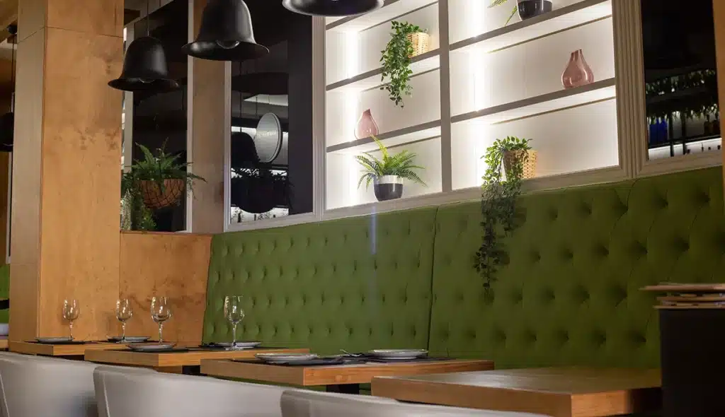 Deep Diamond Button Back booth seating in a extra high back style in front of a feature wall in a restaurant