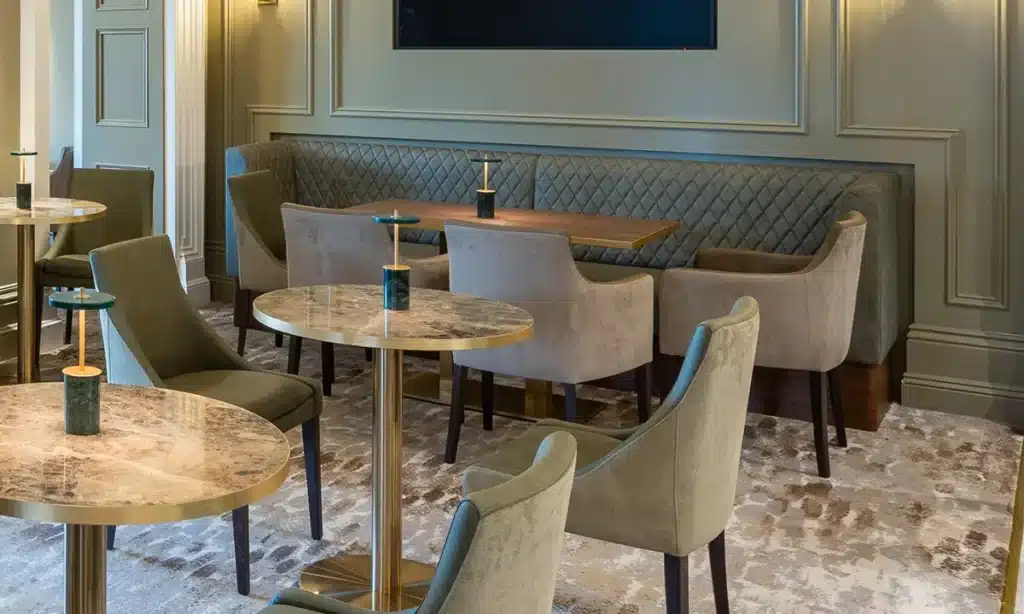 luxury high end cafe restaurant interior with marble tables, L shaped quilted booth set in the corner