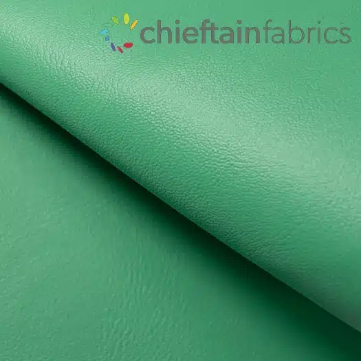 Close-up of green faux leather fabric with a folded edge.